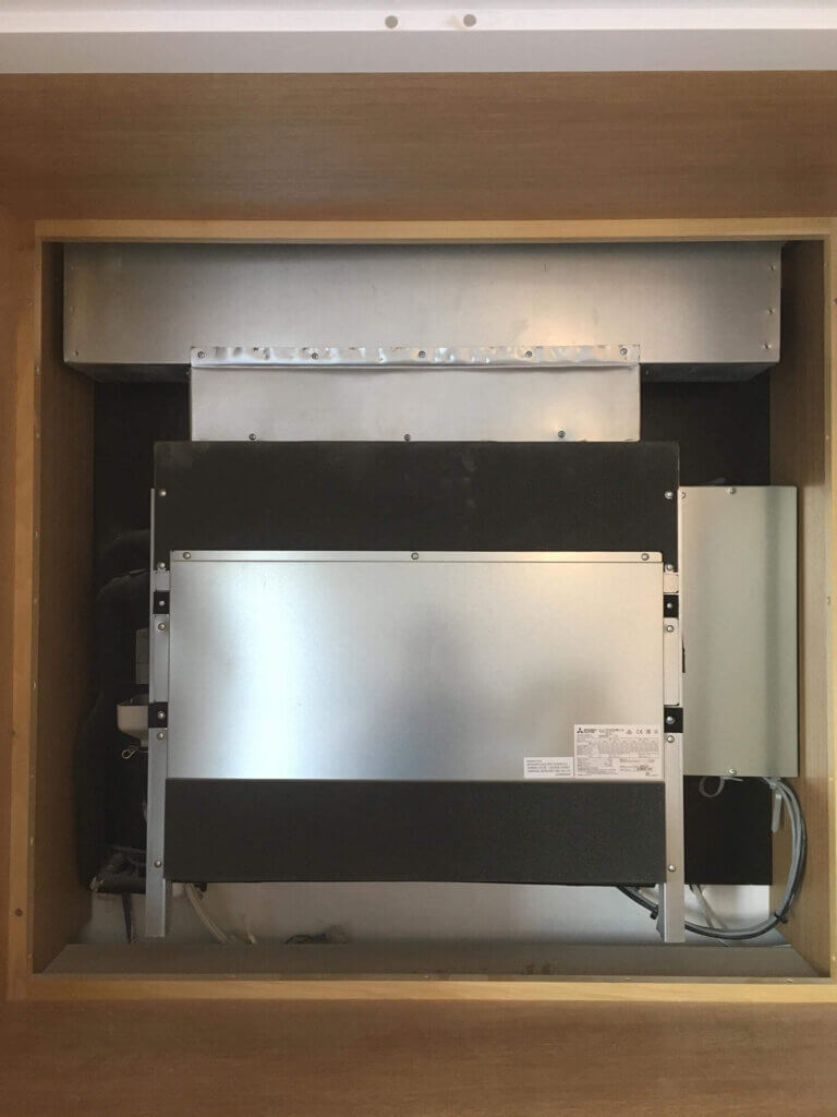 Air conditioning equipment concealed behind the back of bespoke joinery