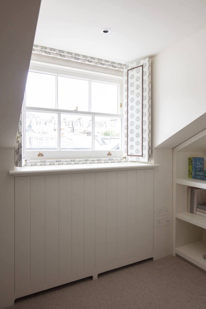 Access through windowsill joinery to air conditioning equipment in a luxury bedroom in Kensington