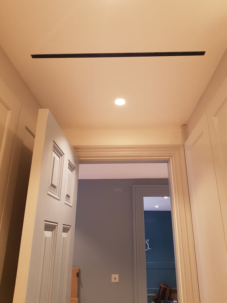 Slim single slot diffuser in the ceiling in a luxury Kensington residence for air conditioning