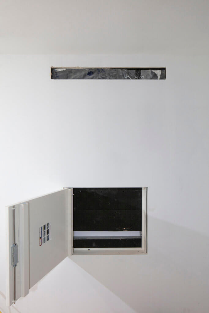 Access panels to air conditioning equipment concealed in the wall void for discreet climate control