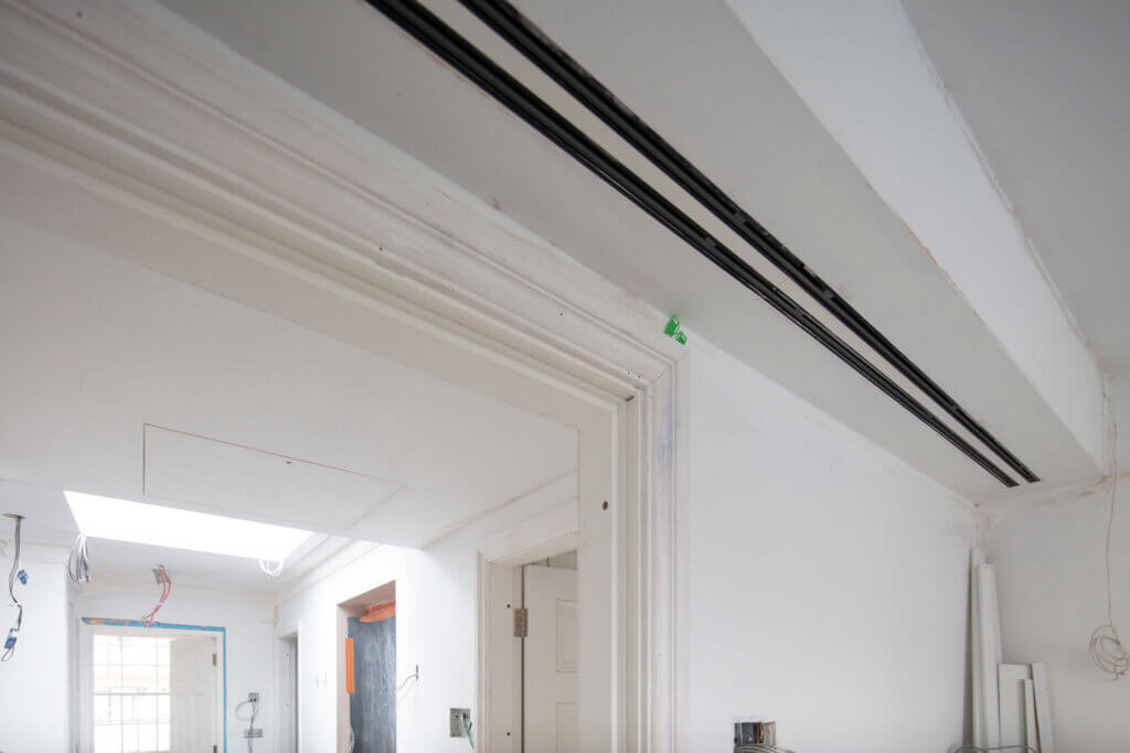 Twin slot diffusers over the doorway for air conditioning to a Kensington luxury residence