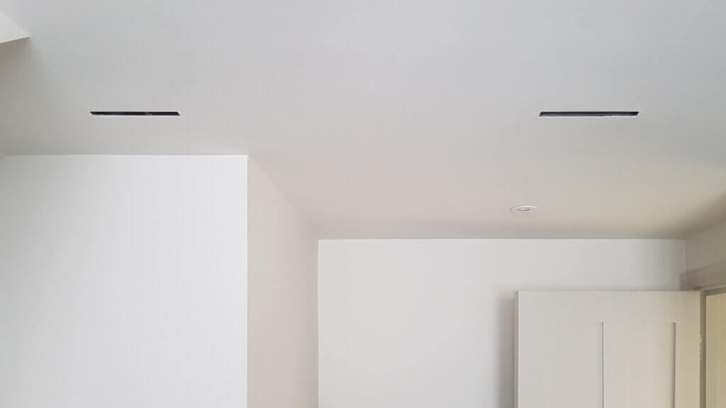 Slim ceiling slot diffusers for air conditioning in a Wimbledon new build arts and crafts property