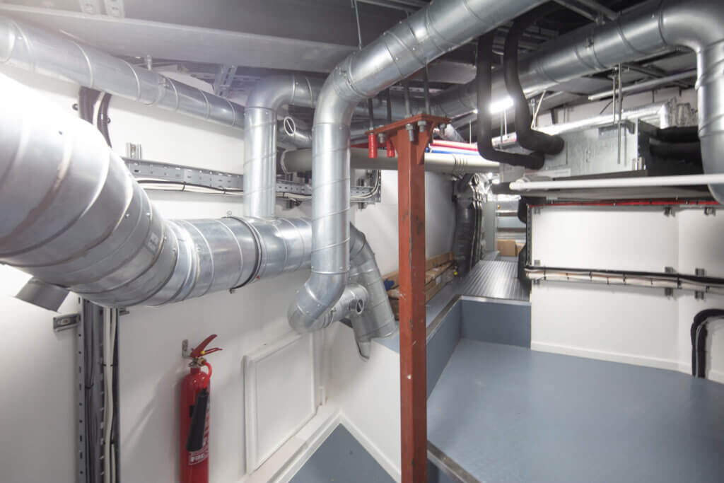 Ventilation and air conditioning pipework and ductwork concealed in the roof void in a Battersea penthouse