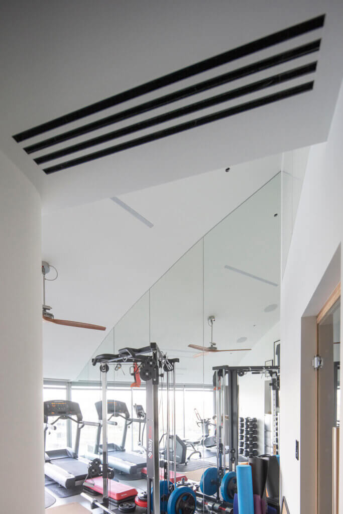 Multi-slot diffuser in the gym doorway ceiling for ventilation in a Battersea penthouse with views over the Thames