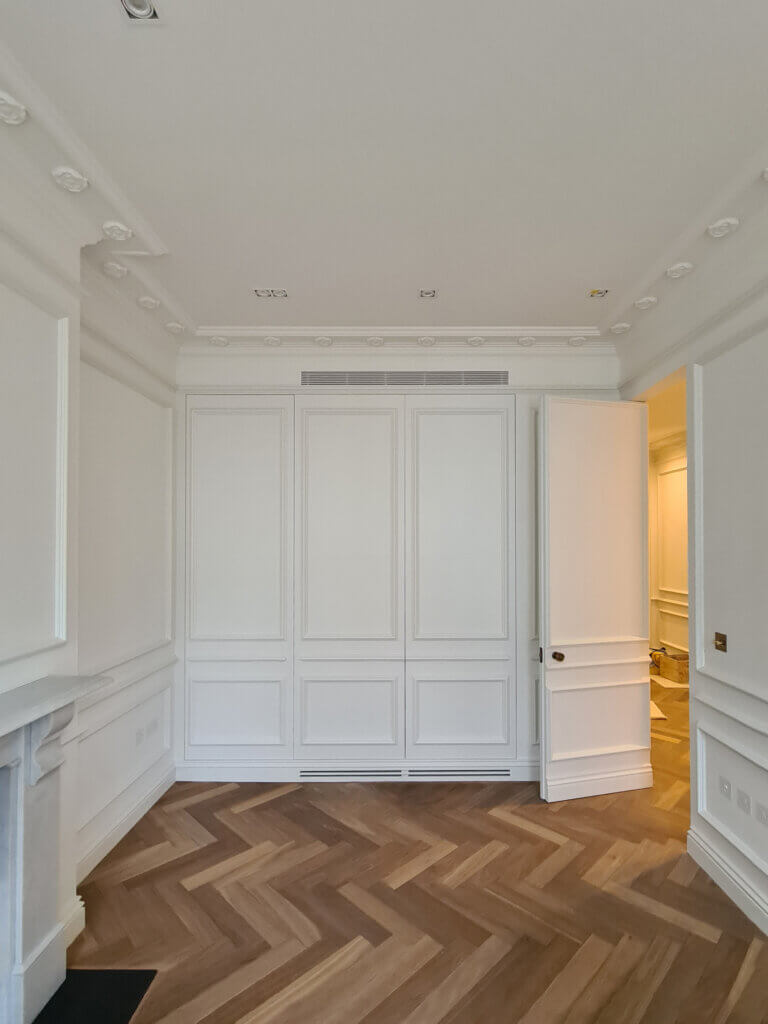 Supply and return paths for air conditioning through a plaster in linear bar grille and discreet joinery slots in the plinth for air conditioning in a luxury apartment renovation in Notting Hill