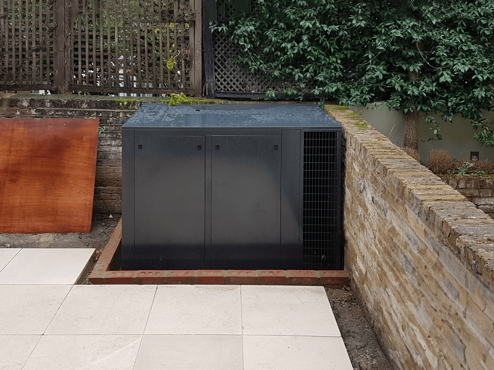 External acoustic enclosures for silent air conditioning concealed in the garden in a London conservation area
