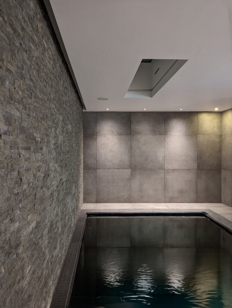 Concealed slot diffusers in the ceiling light recesses for pool ventilation in a luxury refurbishment in Kensington