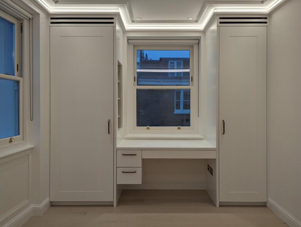Joinery slots in dressing room cabinetry of the master suite for luxury air conditioning in a Kensington townhouse